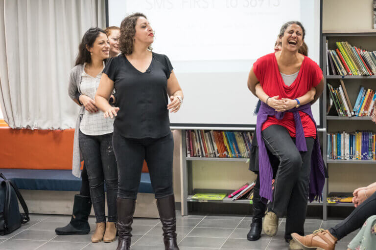 משתתפות מ צוות חינוך צוחקות במשחק אימפרוב | אימפרוביזציה עם הילה די קאסטרו בסדנה | פעילות לצוותי חינוך בנושא מגדר של 20000 מילים | 20,000 מילים | עשרים אלף מילים משחקות מגדר